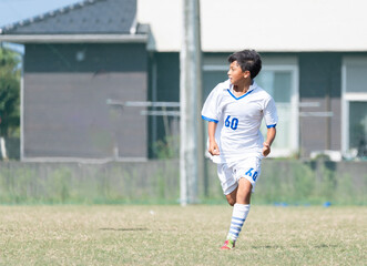 サッカーの試合をする中学生の男の子