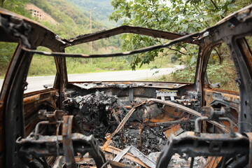 Abandoned Burnt Car Wreck on Mountain Roadside