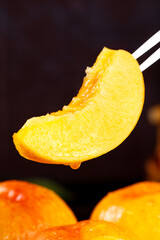 Fresh Golden Nectarine Slice in Tweezers - Juicy Stone Fruit Close-up