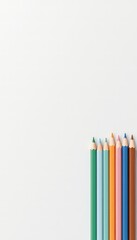 Fototapeta premium Row of pastel colored pencils arranged on a plain background, art supplies ready for coloring and drawing projects