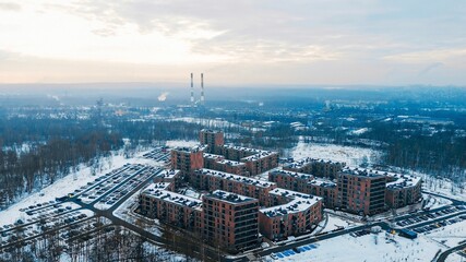 Modern housing development surrounded by snowy forest