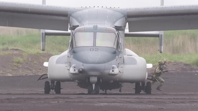 Personnel moving swiftly from a military aircraft