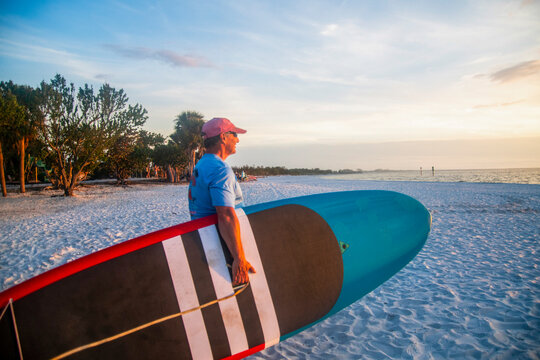 Active Seniors embrace Paddleboarding  at sunset