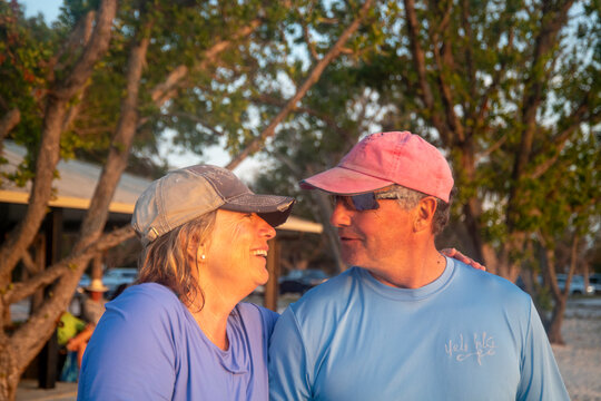 Active Seniors embrace Paddleboarding  at sunset
