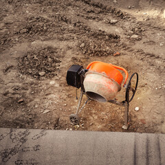 Orange cement mixer on building site
