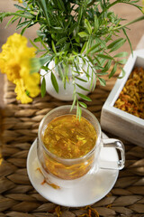 Herbal tea brewed with fresh flowers in a cozy setting surrounded by natural elements