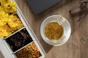 Herbal tea preparation at a cozy table with colorful dried flowers and a relaxing atmosphere in a home setting