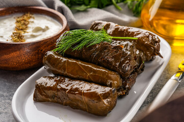 Delicious Turkish dish, stuffed grape leaves, on a stone table