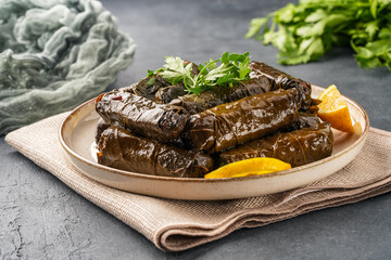 Delicious Turkish dish, stuffed vine leaves, on a black stone table