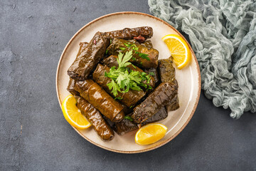Delicious Turkish dish, stuffed vine leaves, on a black stone table