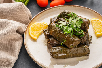 Delicious Turkish dish, stuffed vine leaves, on a black stone table