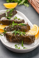Delicious Turkish dish, stuffed vine leaves, on a black stone table