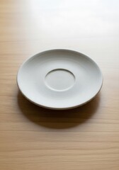 Simple white ceramic saucer sits upon a clean wood grain surface
