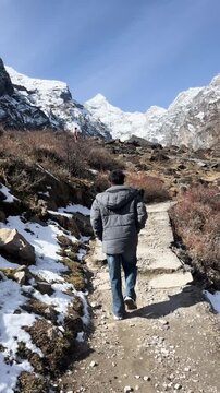 October 2023, Neelkanth Mountain view from Badrinath, Chamoli district, Uttarakhand, India, with a person walking towards the snow-covered Himalayan peak