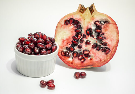 Halved pomegranate and its red seeds for juice, grenadine
