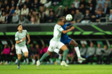 Obraz premium Silhouette of players in action during football match at stadium with intentional blurry.