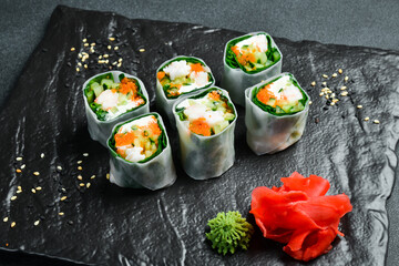 Traditional fresh Japanese sushi rolls with shrimp in a rice sheet. Served with wasabi sauce and pickled ginger. Close up.