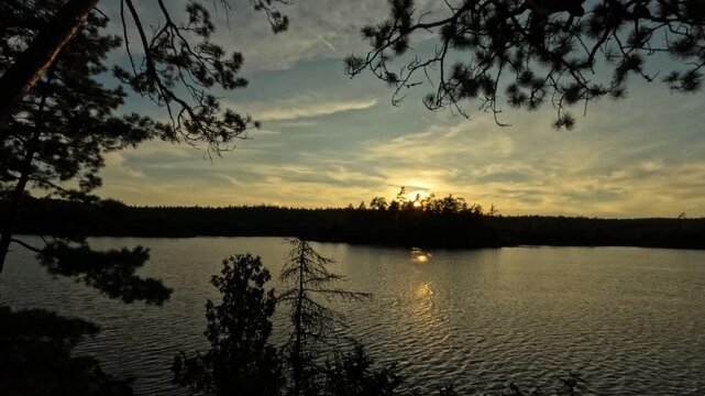 Sunset over a remote Temagami lake in Northern Ontario with golden light reflecting on still waters