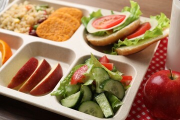 Plastic tray with tasty food on table, closeup. School lunch