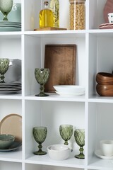 Shelving unit with different dishware, glasses and other kitchen utensils indoors