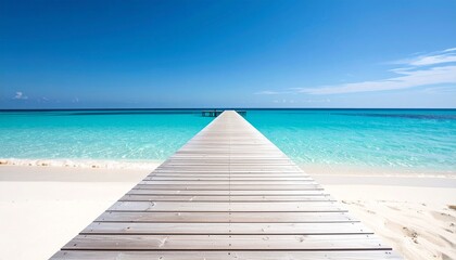 Obraz premium Long wooden pier stretching from a pristine white sand beach into the calm, turquoise water of a tropical sea under a clear blue sky