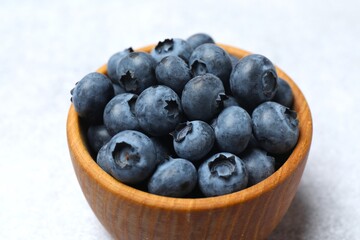 Delicious fresh blueberries in a bowl on the table, close-up
