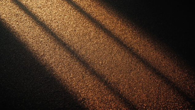 Sunbeams casting parallel shadows on a textured surface.