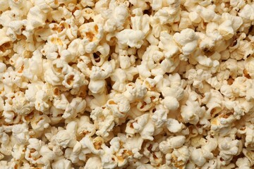 Fresh tasty popcorn as background, closeup view