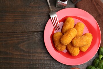 Delicious fried croquettes served on wooden table, flat lay. Space for text