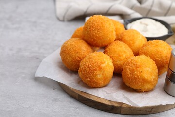 Delicious fried croquette balls on gray textured table, closeup