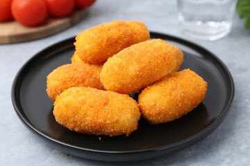 Delicious fried croquettes on gray table, closeup