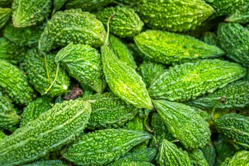 Fresh bitter gourd with a vibrant green texture and natural patterns, symbolizing a healthy food, organic lifestyle, and delicious ingredients for Asian cuisine.