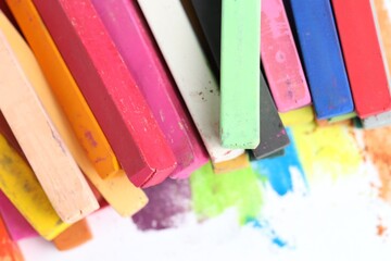 Many colorful chalk pastels on white background, closeup
