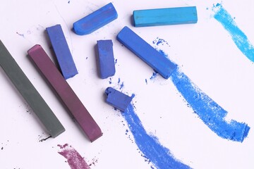 Colorful chalk pastels on white background, flat lay
