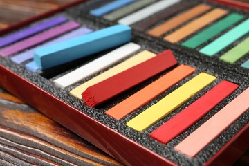 Set of colorful chalk pastels on wooden table, closeup