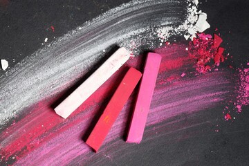 Colorful chalk pastels on black background, flat lay
