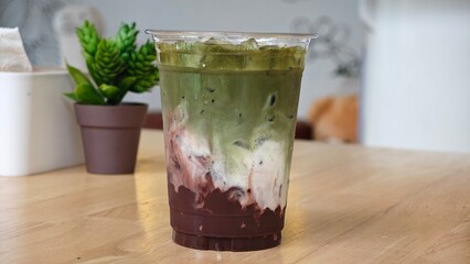 Iced matcha cocoa drink in plastic glass.