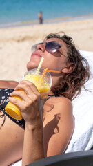 Woman relaxing on beach with drink