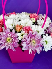 colorful flower arrangement in pink box