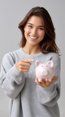 Woman holding piggy bank and pointing to it personal finance savings and banking concept