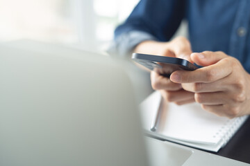 Business woman using mobile smart phone and online working on laptop computer, surfing the internet, searching the information at office. Female student online studying from home, e-learning