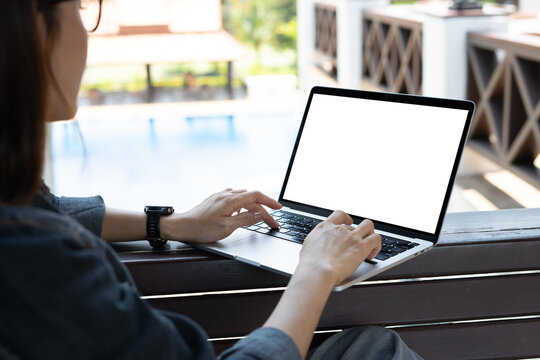 Mockup, woman using laptop with blank white screen at outdoors cafe,  Freelancer, digital nomad working on laptop, emplty screen for online marketing design, closeup