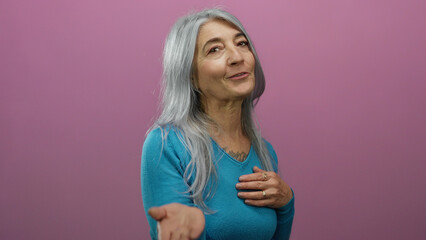Elderly woman in blue sweater blows a kiss against a pink background conveying warmth and affection...