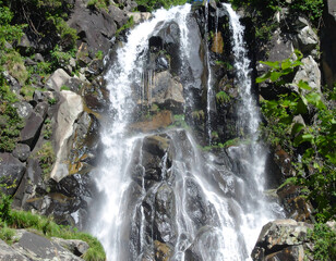 Waterfall cascades over dark rocks