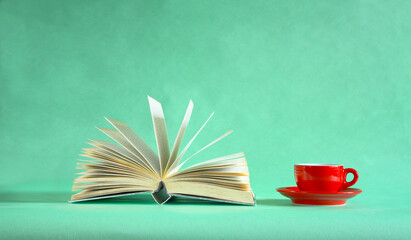 Open book and cup of coffee, Reading, learning, education, knowledge or home office concept.Close up shot with smooth narrow depth of field, free copy space.