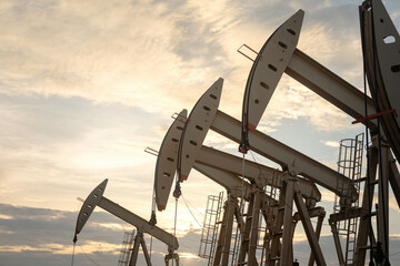 Beam pump or Donkey pump operating to recovered crude oil from the production oil well, with highlight sky background. Industrial with technology scene.