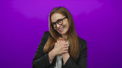 Woman in black blazer and white shirt clutch chest and wince in purple studio expressing sudden...