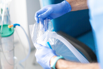 Surgeon preparing sterile medical equipment for operation in hospital room