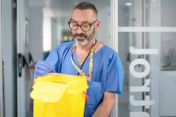Doctor disposing of medical waste in a sharps container in hospital setting