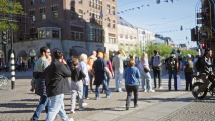 Urban scene featuring blurred people walking in a european city with a defocused background highlighting street activity and architectural elements under bright sunny weather. © Krakenimages.com